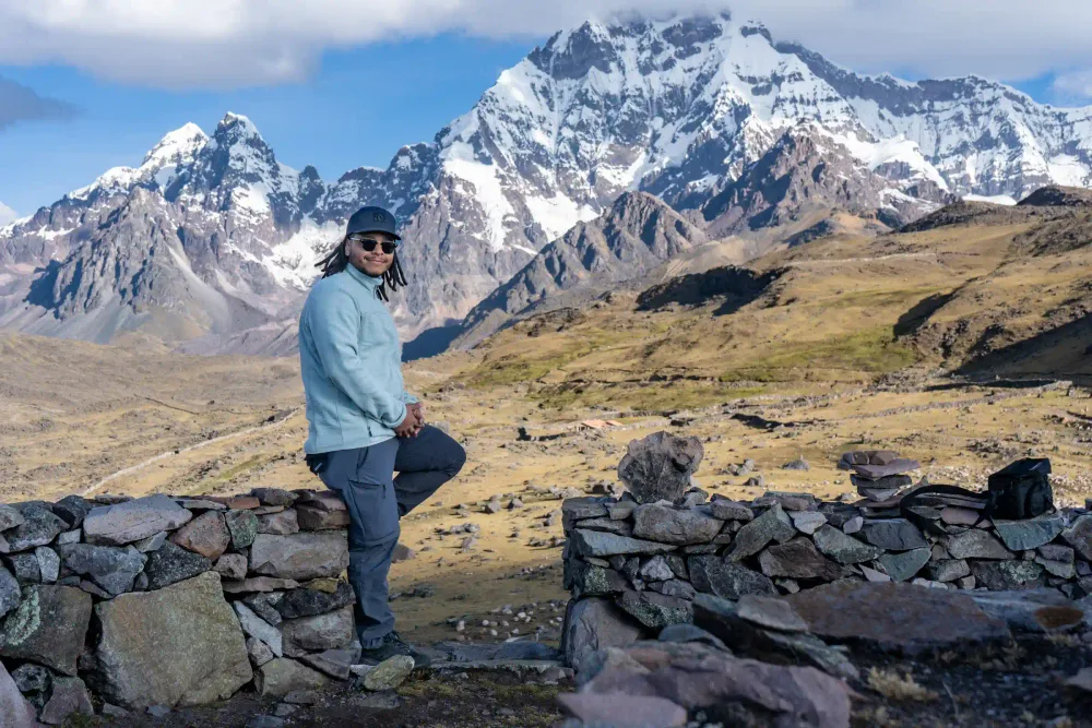 A hiker in front of the towering snow-capped Ausangate glacier