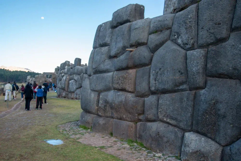 Visitors beside the great Inca walls of Sacsayhuamán at dusk