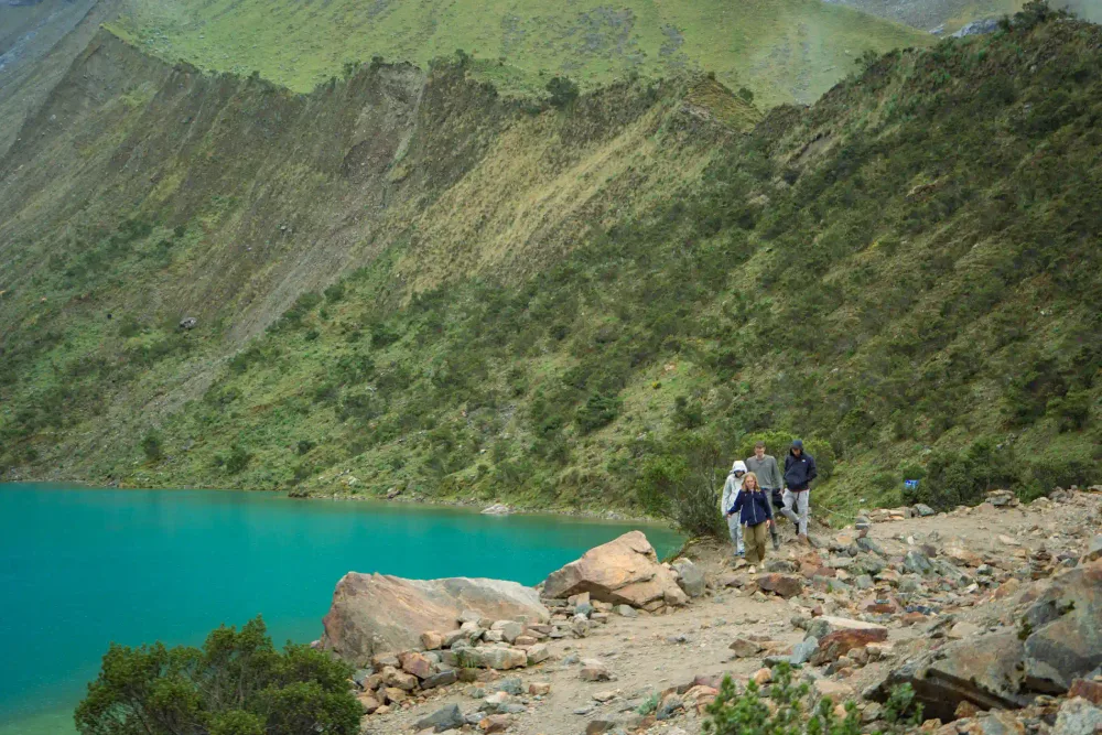 Hikers beside Humantay Lake showing the scale of the landscape
