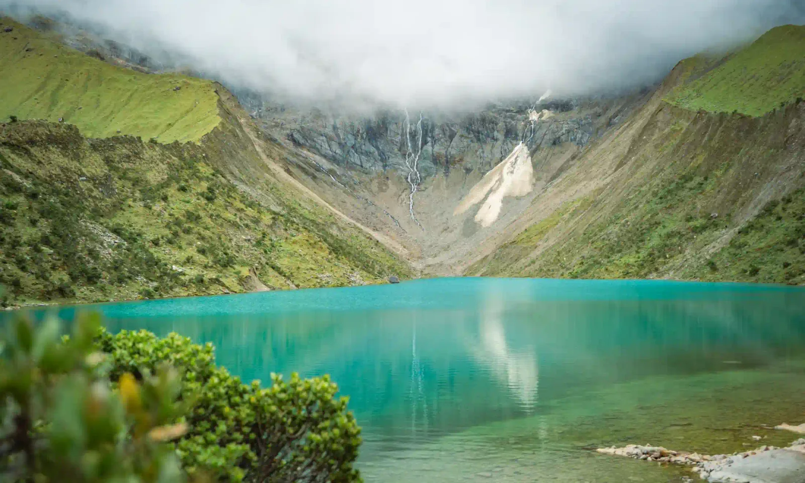 The turquoise glacial Humantay Lake below the snow-capped Humantay peak near Cusco