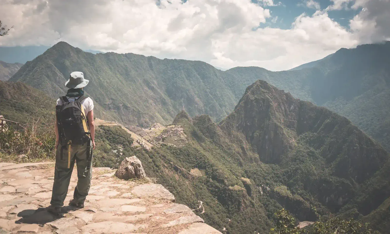 Trekker on the Inca Trail looking toward Machu Picchu from the Sun Gate viewpoint