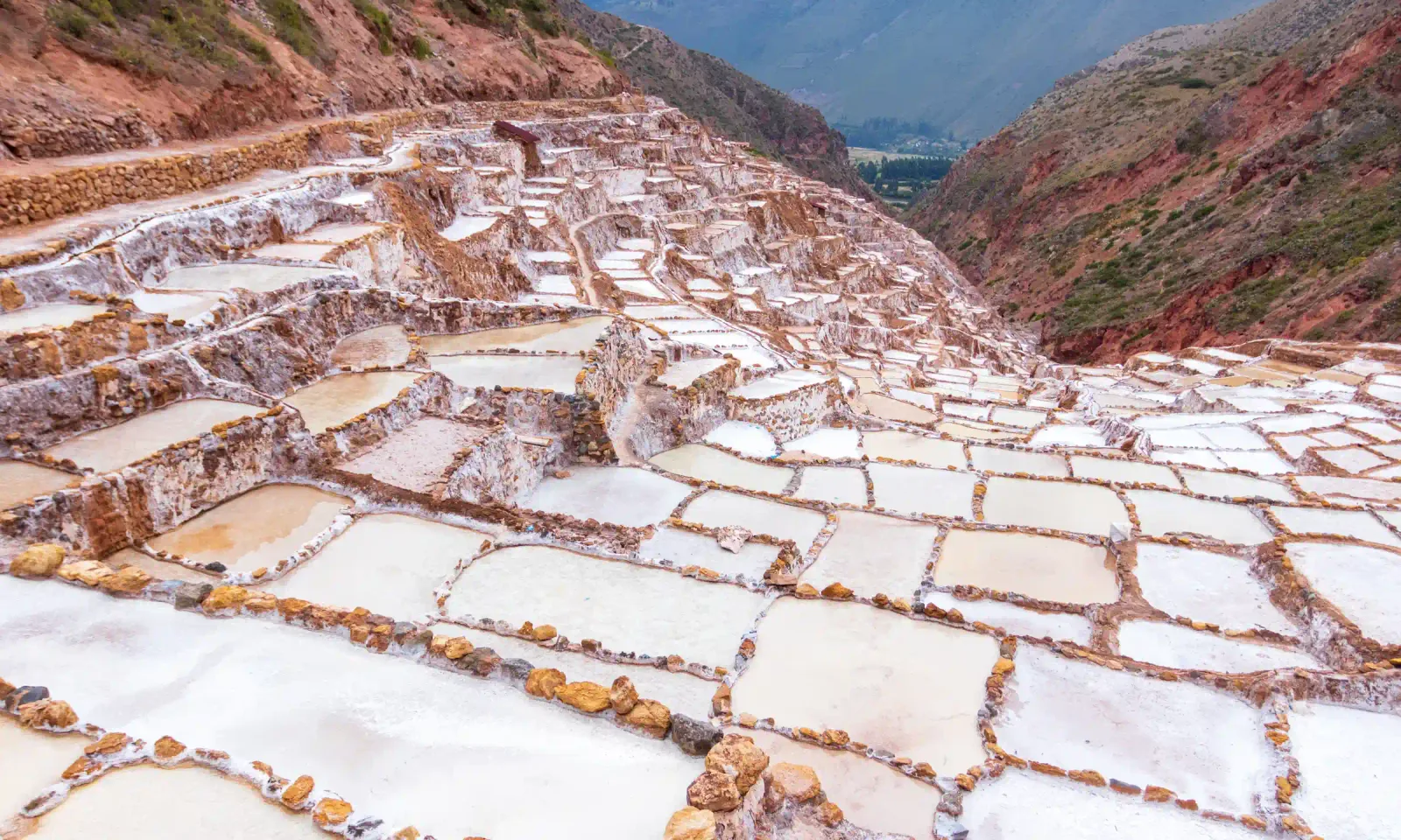 Panoramic view of the Maras salt pans cascading toward the Sacred Valley near Cusco