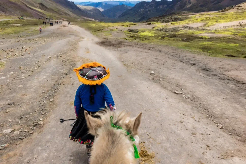 A local woman on horseback on the trail to Rainbow Mountain